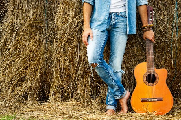 Jambes masculines et guitare acoustique