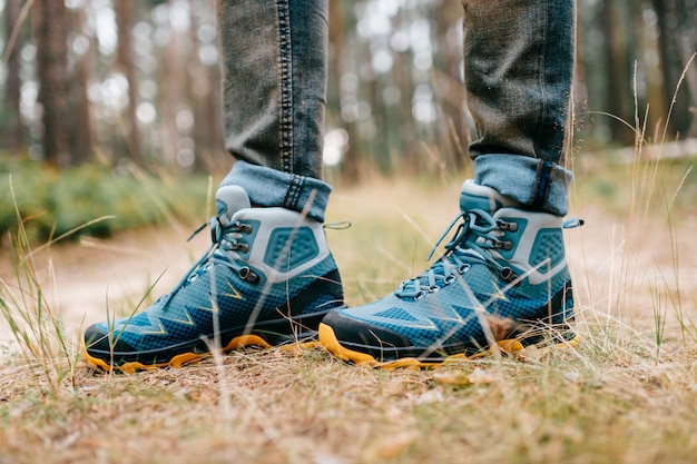 Photo jambes masculines portant des chaussures de randonnée sportives. jambes d'hommes dans des bottes de randonnée pour les activités de plein air