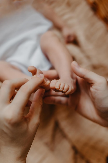 Jambes d'un nouveau-né entre les mains de ses parents