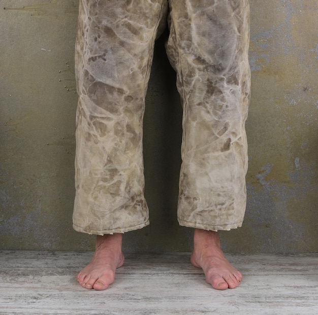 Photo les jambes nues d'un homme dans un vieux pantalon