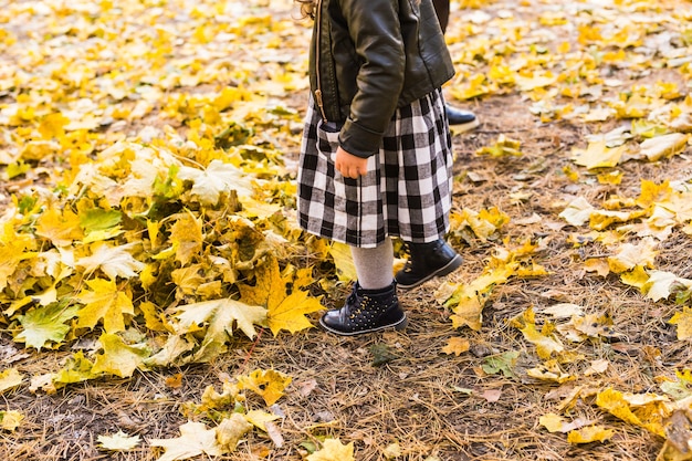 Jambes de petite fille en arrière-plan d'automne.
