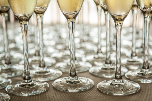 Jambes de verres avec du champagne froid, des gros plans