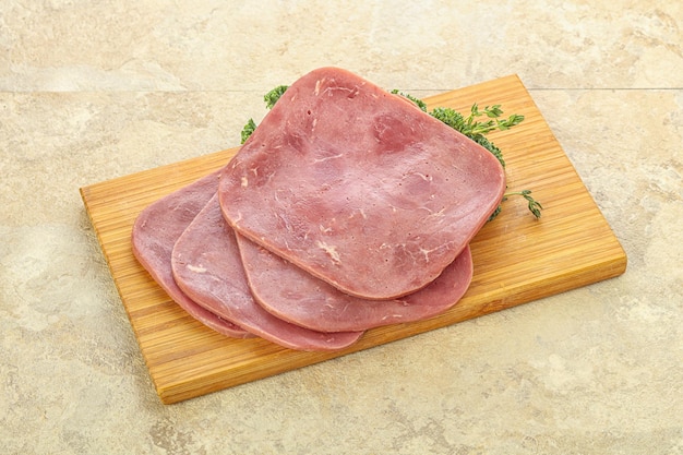 Jambon de boeuf tranché sur planche