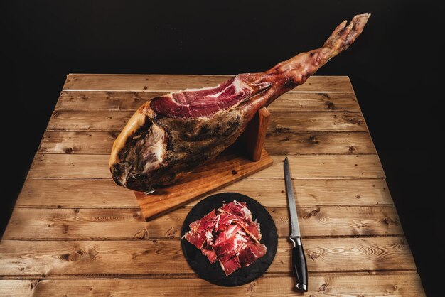 Photo jambon espagnol avec une assiette avec du jambon en tranches et un couteau