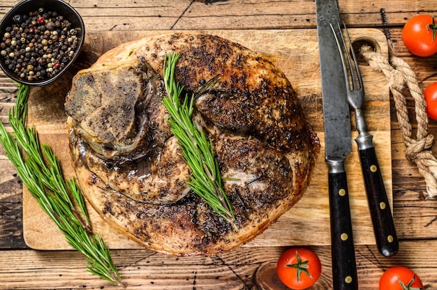 Jambon de porc rôti sur une planche à découper. Viande de jarret.