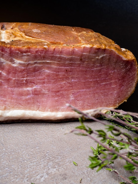 Jambon rôti à l'ail au thym frais sur table grise