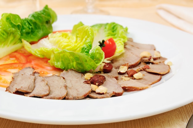 Jambon tranché avec légumes sur plat au restaurant