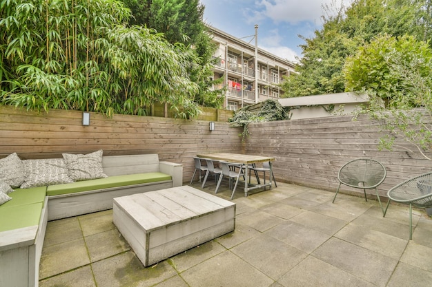 Un jardin avec une clôture en bois et une table et