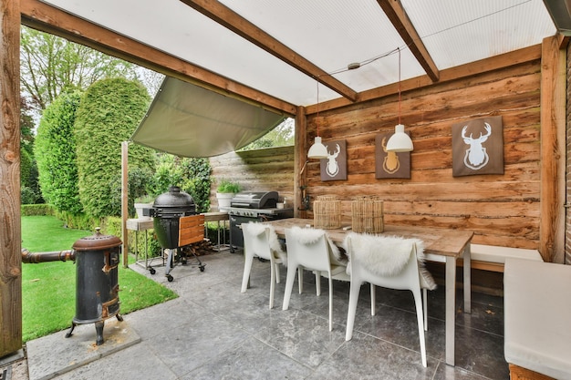 Un jardin avec une table et des chaises et un grill