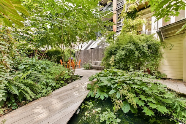 Un jardin avec une terrasse en bois et un étang