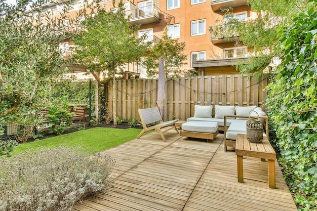 Un jardin avec une terrasse en bois avec des meubles et un