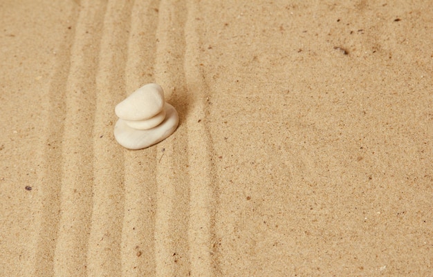 Jardin zen avec du sable ratissé et des pierres rondes se bouchent