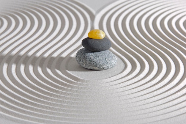 Photo jardin zen japonais avec de la pierre dans du sable texturé