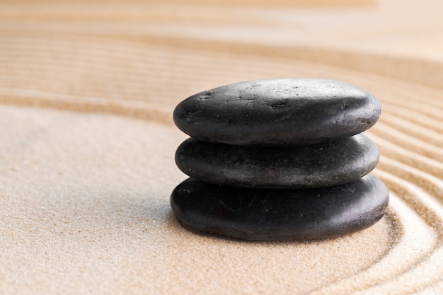 Jardin zen japonais avec pierre dans le sable ratissé