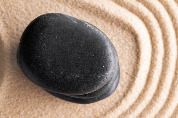 Photo jardin zen japonais avec pierre dans le sable ratissé