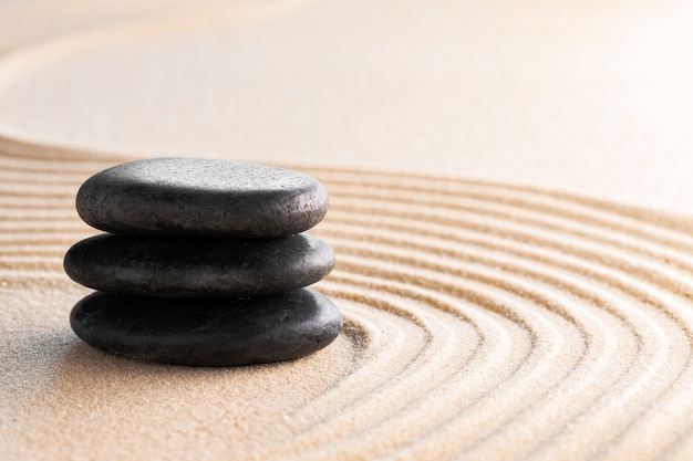 Jardin zen japonais avec pierre dans le sable ratissé