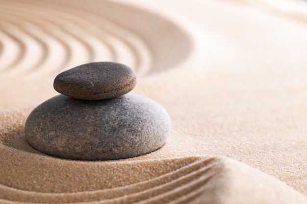 Jardin zen japonais avec pierre dans le sable ratissé