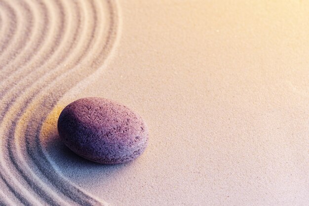 Jardin zen de méditation avec des pierres sur le sable