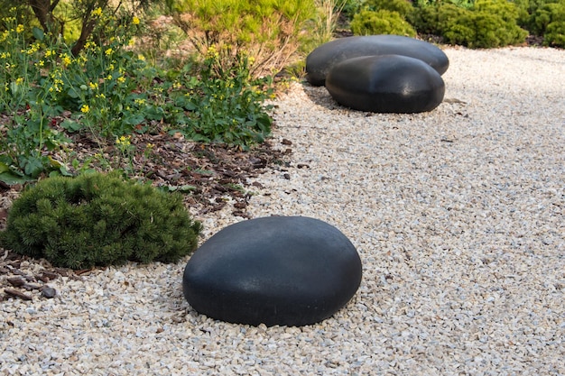 Jardin zen paysage sec ou rocaille japonaise karesansui avec pierres noires sur gravier blanc pour re...