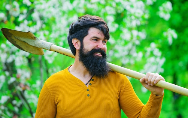 Jardinage de printemps. Jardinier barbu avec bêche de jardinage. Homme souriant se préparant à planter.