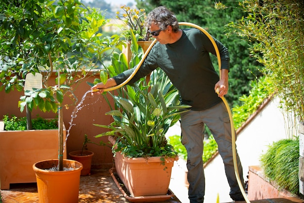 jardinier arrosant les plantes par une journée ensoleillée