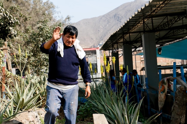 Jardinier dans un jardin scolaire à côté de plantes d'Aloe vera