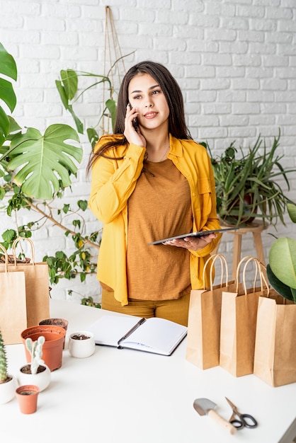 Photo jardinier de femme travaillant sur tablette numérique et passer un appel