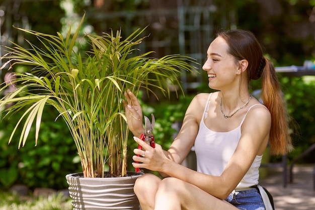 Jardinier de fille s'occupant des usines avec un sourire