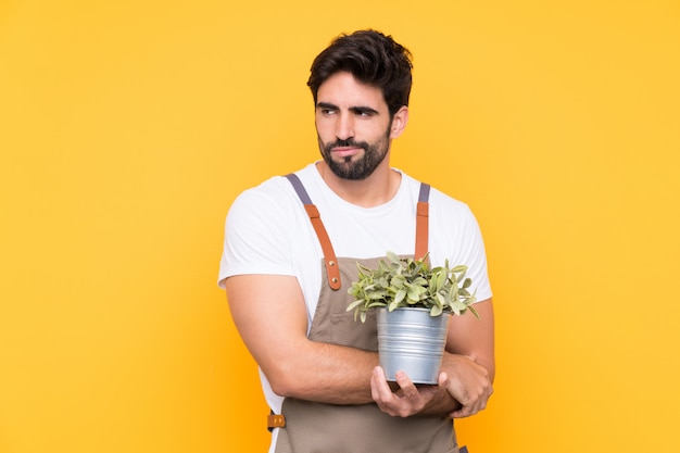 Jardinier homme sur mur jaune isolé