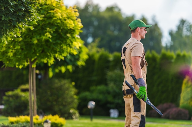 Jardinier professionnel lors des travaux d'entretien du paysage du jardin