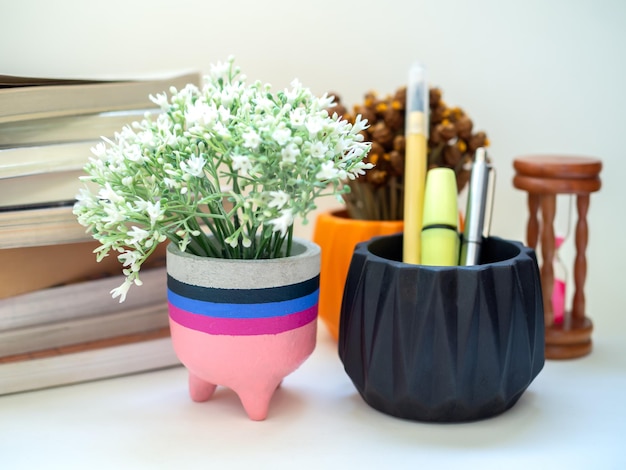 Jardinière en béton moderne colorée avec sablier fleuri et livres