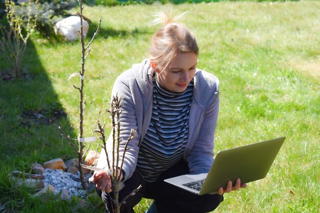 jardinière avec ordinateur portable, analyse des cultures, exploitation agricole.