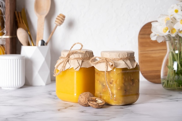 Photo des jarres avec du miel et des noix noix dans du miel à l'intérieur de la cuisine