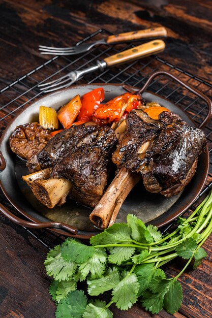 Jarrets D'agneau Braisés Faits Maison Avec Sauce Et Herbes Dans Un Plateau En Acier Fond En Bois Vue De Dessus