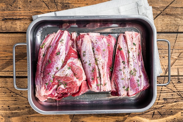 Jarrets d'agneau marinés aux herbes, épices et thym Viande de mouton prête pour la cuisson Fond en bois Vue du dessus