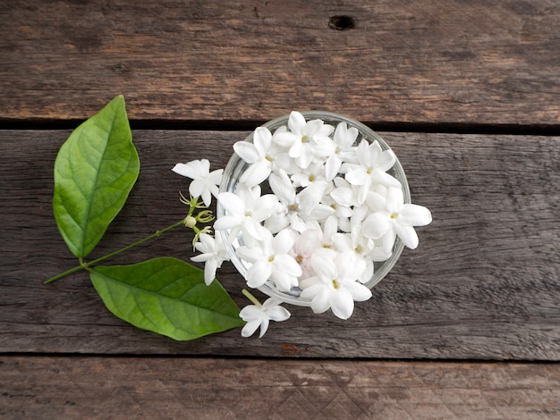 Jasmin Flottant Dans Un Verre Clair Sur Fond En Bois.