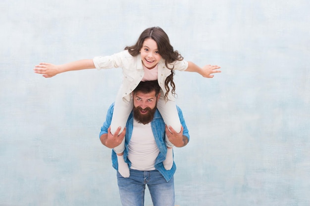 Je crois que je peux voler. Heureux père ferroutage petite fille. Un homme barbu et un petit enfant jouent ensemble. S'amuser. Jeux actifs. Partage des relations de confiance. Confiance et amour de la famille. Valeurs familiales.