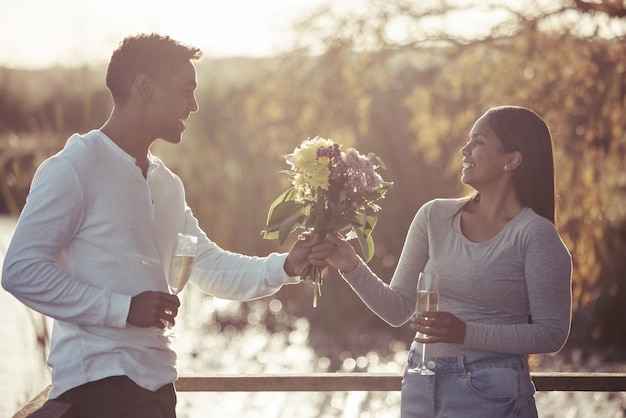 Je devais cueillir des fleurs qui correspondaient à ta beauté Photo d'un beau jeune homme donnant à sa petite amie un bouquet de fleurs lors d'un rendez-vous à l'extérieur