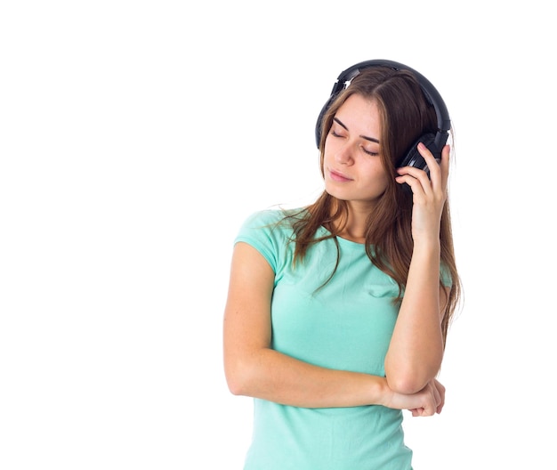 Je me demande une jeune femme en T-shirt bleu écoutant de la musique dans un casque noir en studio