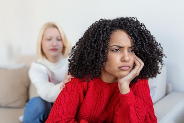 Je ne veux pas entendre Malheureuse femme fatiguée et dérangée communiquant avec son amie assise près d'elle sur le canapé en lui serrant la main Amis se disputant sur le canapé à la maison Deux amies se disputant