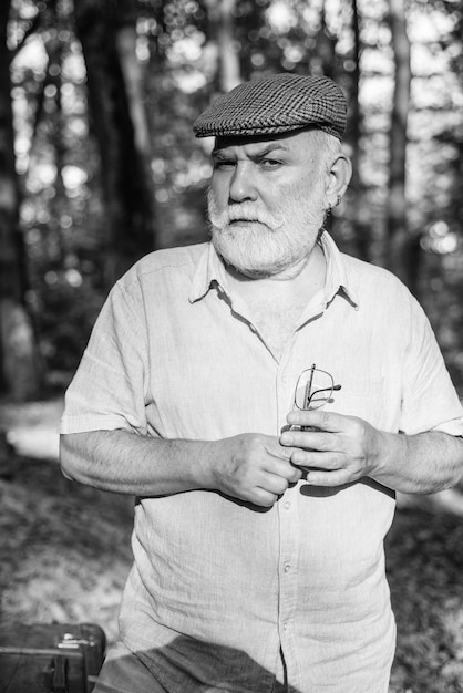 Photo je ne vieillis pas, je vieillis à la perfection. une personne âgée aux cheveux gris et à la barbe se promène à l'extérieur. un homme âgé se détend dans la nature en été.