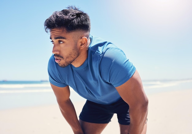 Je pourrais arrêter mais ce serait une perte de temps. Plan d'un homme faisant une pause pendant une course sur la plage.