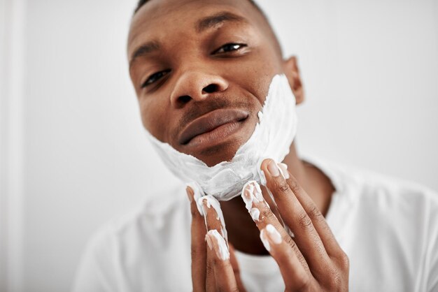 Je préfère tout raser Photo recadrée d'un jeune homme appliquant de la mousse à raser sur son visage