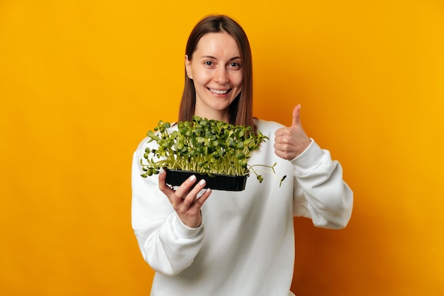 Je recommande ces micro-légumes dit une jeune femme souriante avec le pouce vers le haut