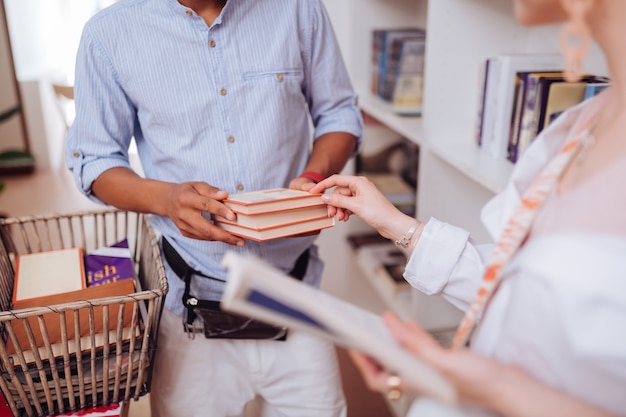 Je recommande. Photo focalisée sur une jeune femme qui tourne la tête en pointant son choix