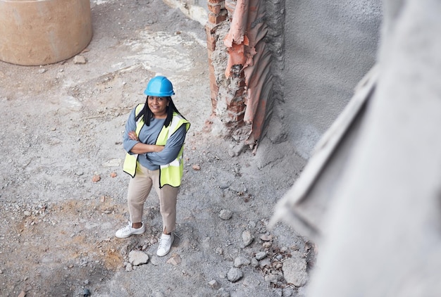 Je suis au travail Portrait en grand angle d'une jolie jeune ouvrière du bâtiment debout les bras croisés sur place