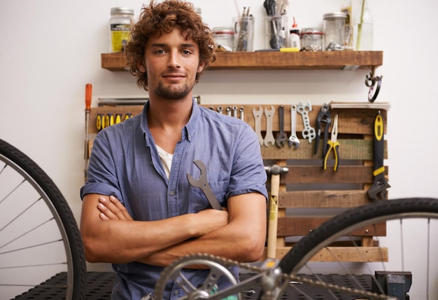 Je suis comme de la superglueJe peux réparer n'importe quoi Photo d'un jeune réparateur de vélos confiant regardant la caméra