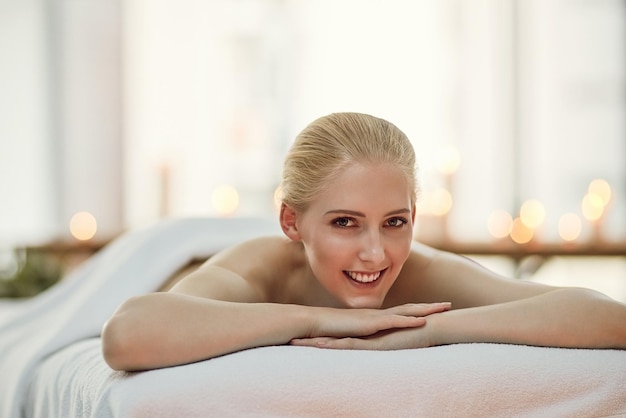 Je suis tellement contente d'avoir décidé de faire aujourd'hui une journée au spa Portrait d'une jeune femme se relaxant sur une table de massage dans un spa