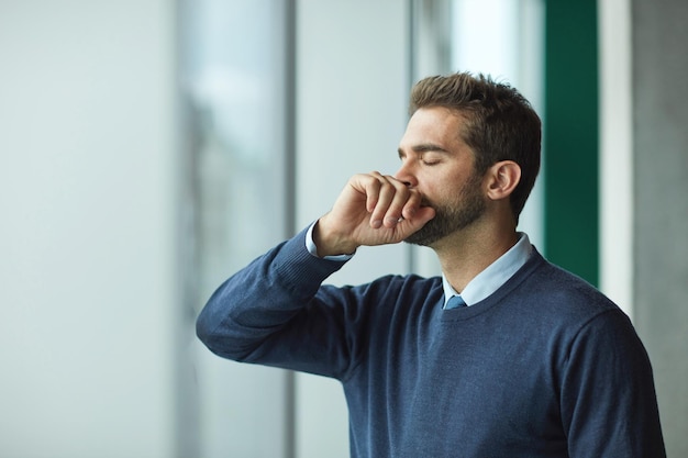 Je suis tellement dépassé. Photo recadrée d'un beau jeune homme d'affaires debout seul à l'intérieur et ayant l'air stressé.