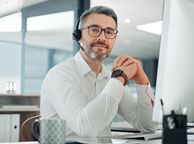 Je suis toujours prêt à conclure des affaires Photo d'un agent du service client mature assis seul au bureau et utilisant son ordinateur